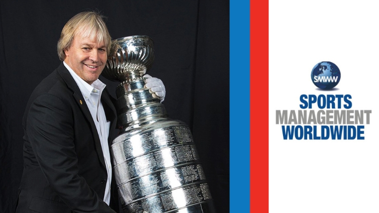 On the backdrop of an NHL hockey arena, Phil Pritchard holds the Stanley Cup. Yellow text overlay says: History of Hockey with Phil Pritchard 'The Keeper of the Cup'. Sports Management Worldwide's logo is in the top right corner.